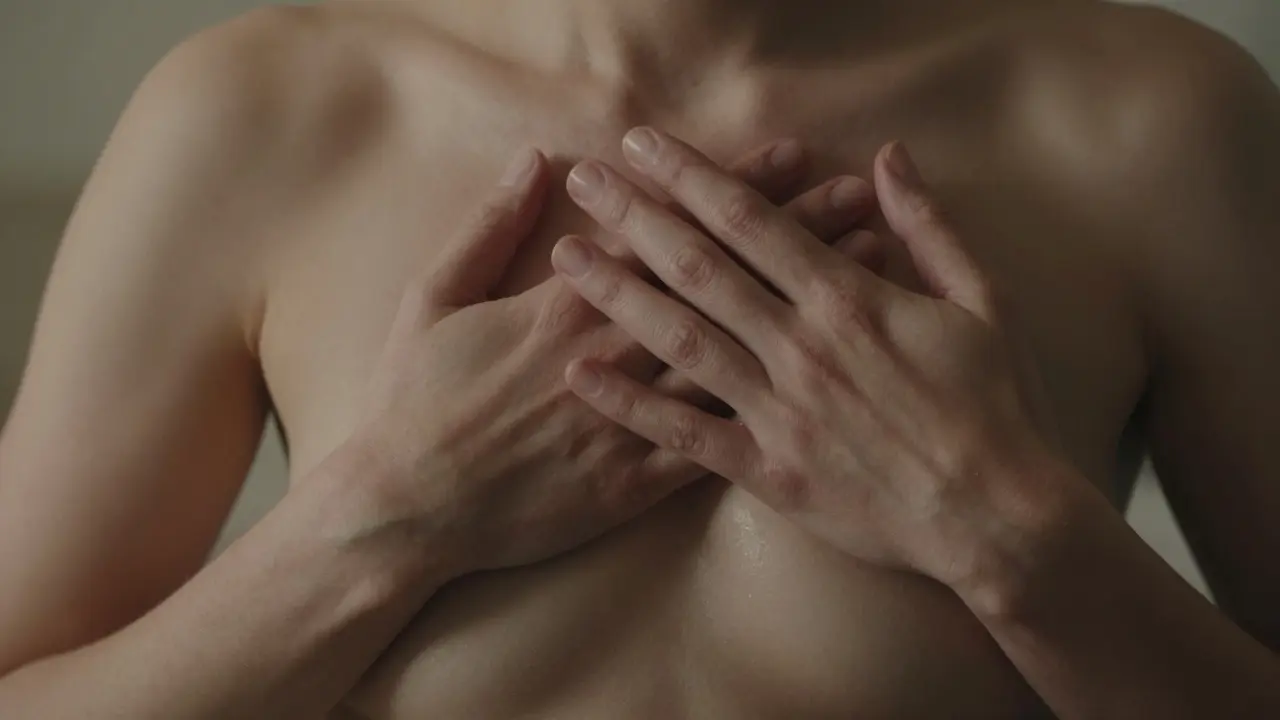 Ruce terapeuta jemně sledují dech na hrudníku a břiše, tělo se uvolňuje v tichém okamžiku.
